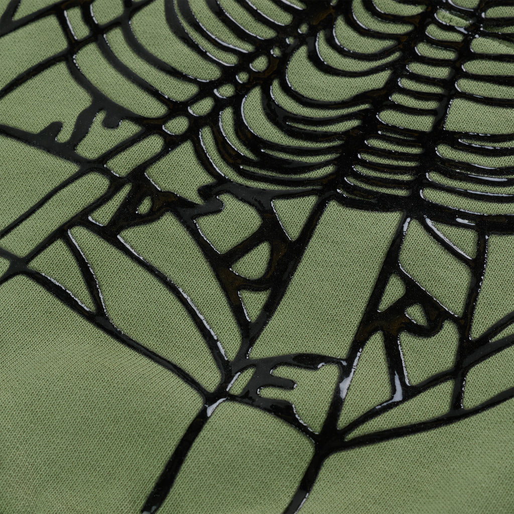 Close-up of OG Web Ombre Hoodie, showing black puff print spiderweb on green 100% cotton fleece.