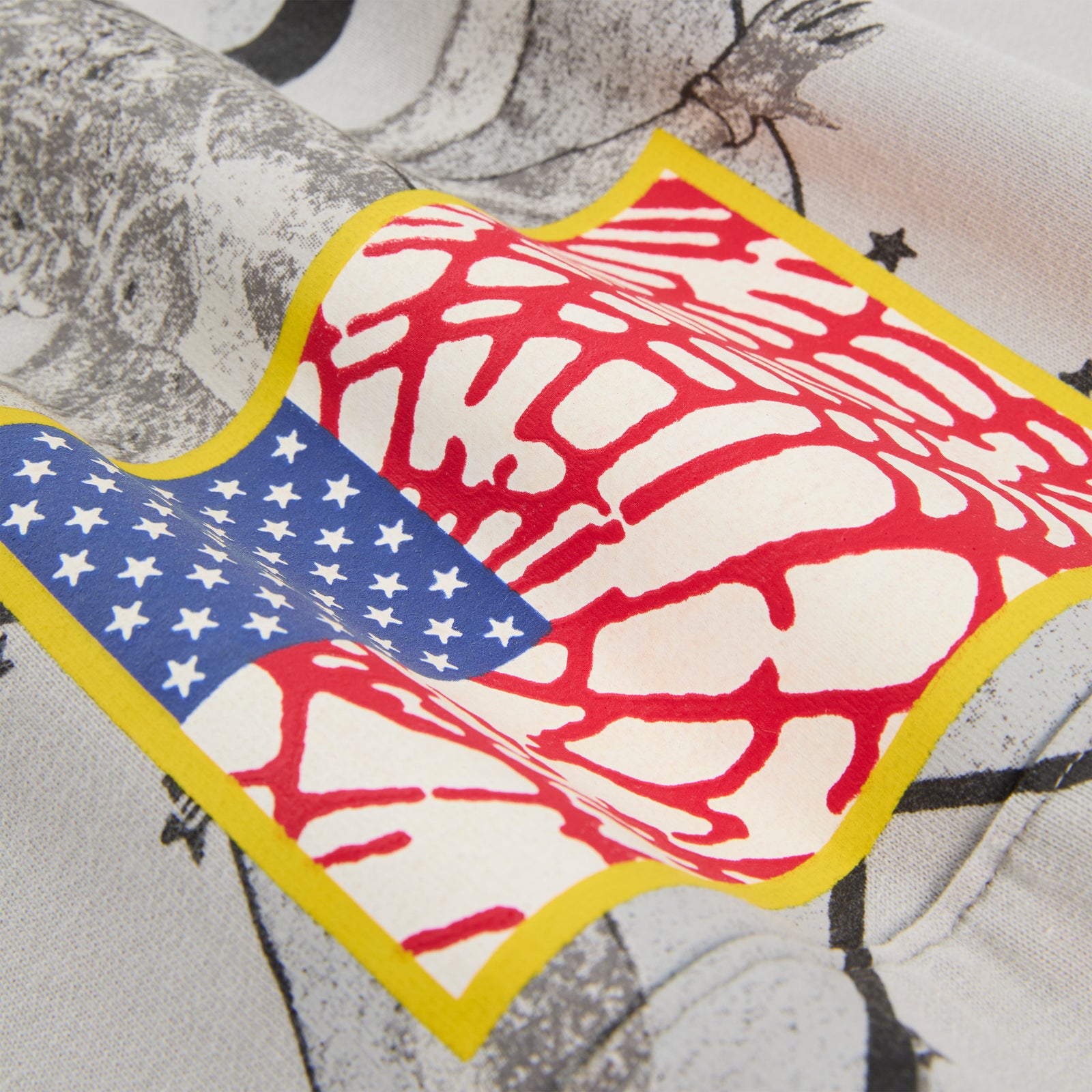 Close-up of a STAR GIRL HOODIE, featuring a graphic print of a distorted American flag with a yellow border.