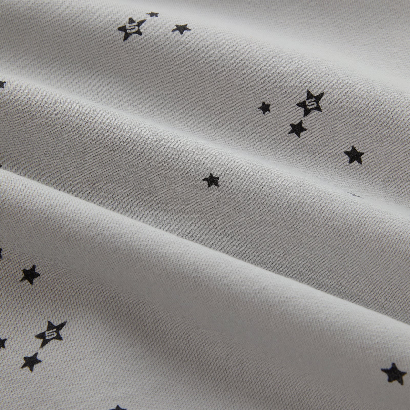 STAR GIRL HOODIE: Light grey 100% cotton fleece with scattered black star print.