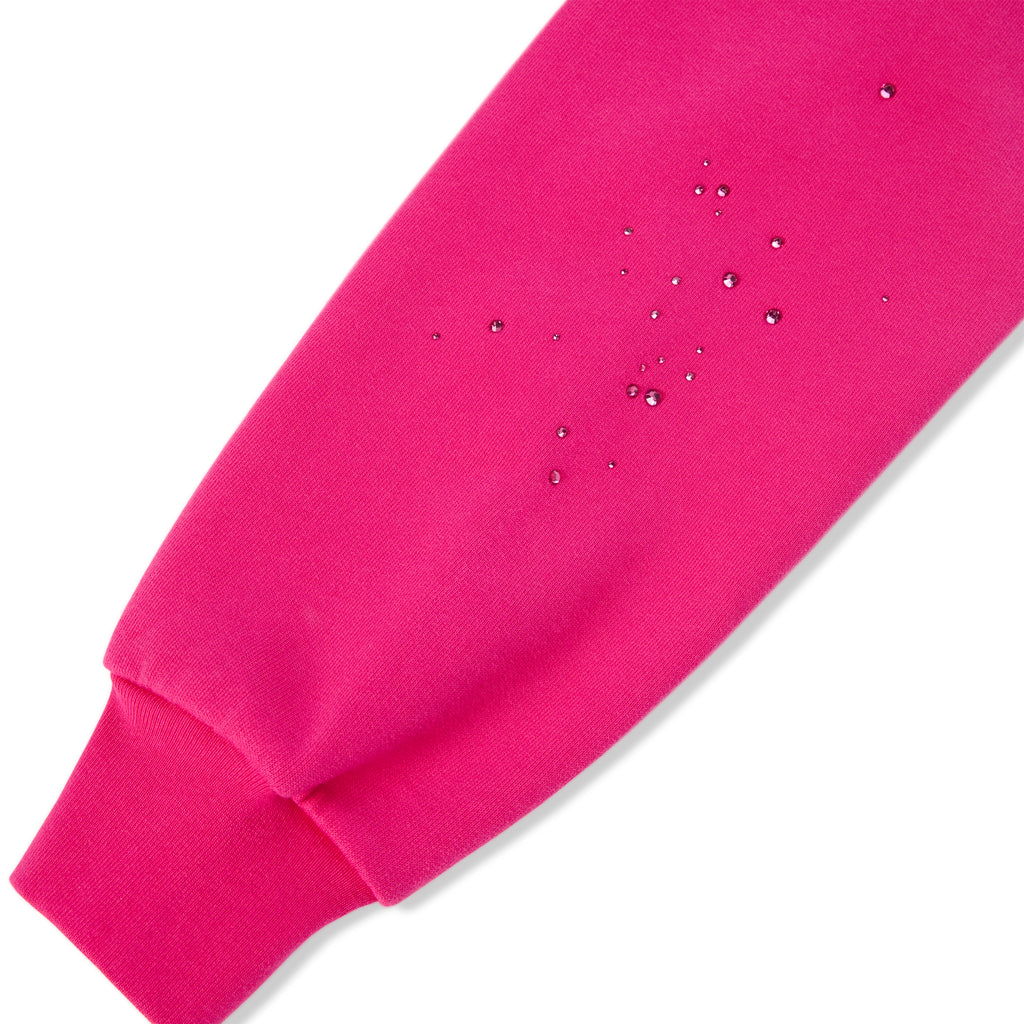 Close-up of a vibrant pink cotton fleece hoodie sleeve with water-repellent droplets.