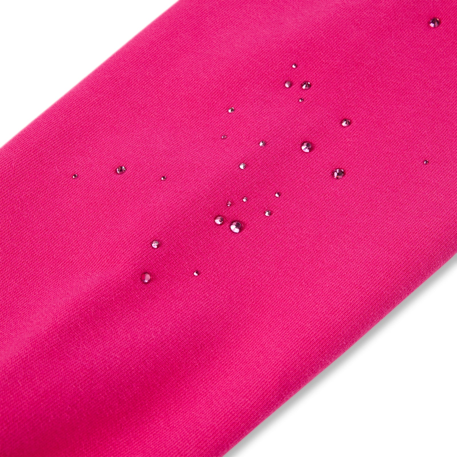 Close-up of a vibrant pink fabric with water droplets, showcasing its water-resistant texture.