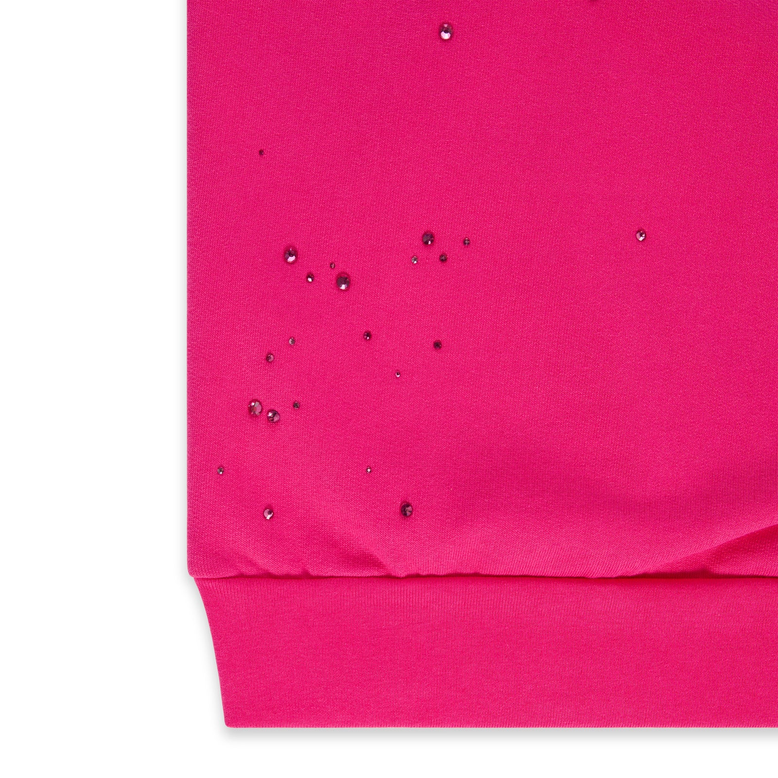 Close-up of a vibrant pink cotton fleece hoodie with scattered rhinestones and a ribbed hem.