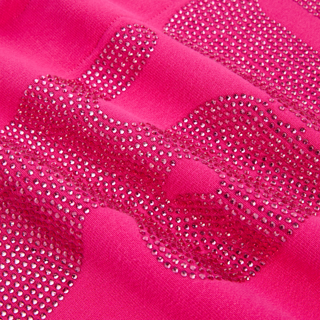 Close-up of a vibrant pink cotton fleece hoodie with sparkling rhinestone design.