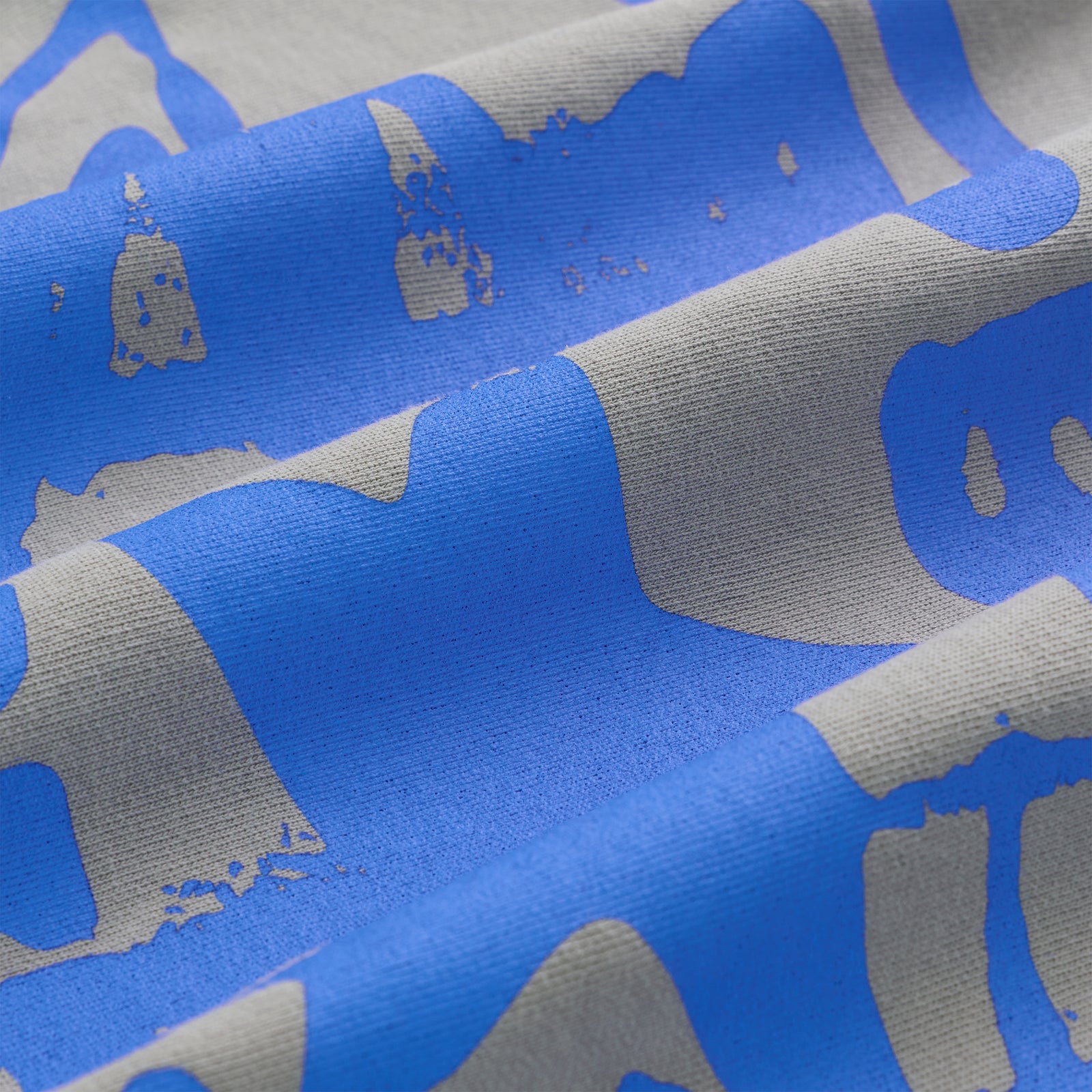 Close-up of SP5DER CUNTRY CREWNECK, light grey 13oz cotton fleece with distressed blue graphic print.