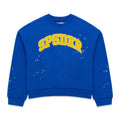 Blue crewneck sweatshirt with yellow "SP5DER" varsity-style lettering and white paint splatter details.