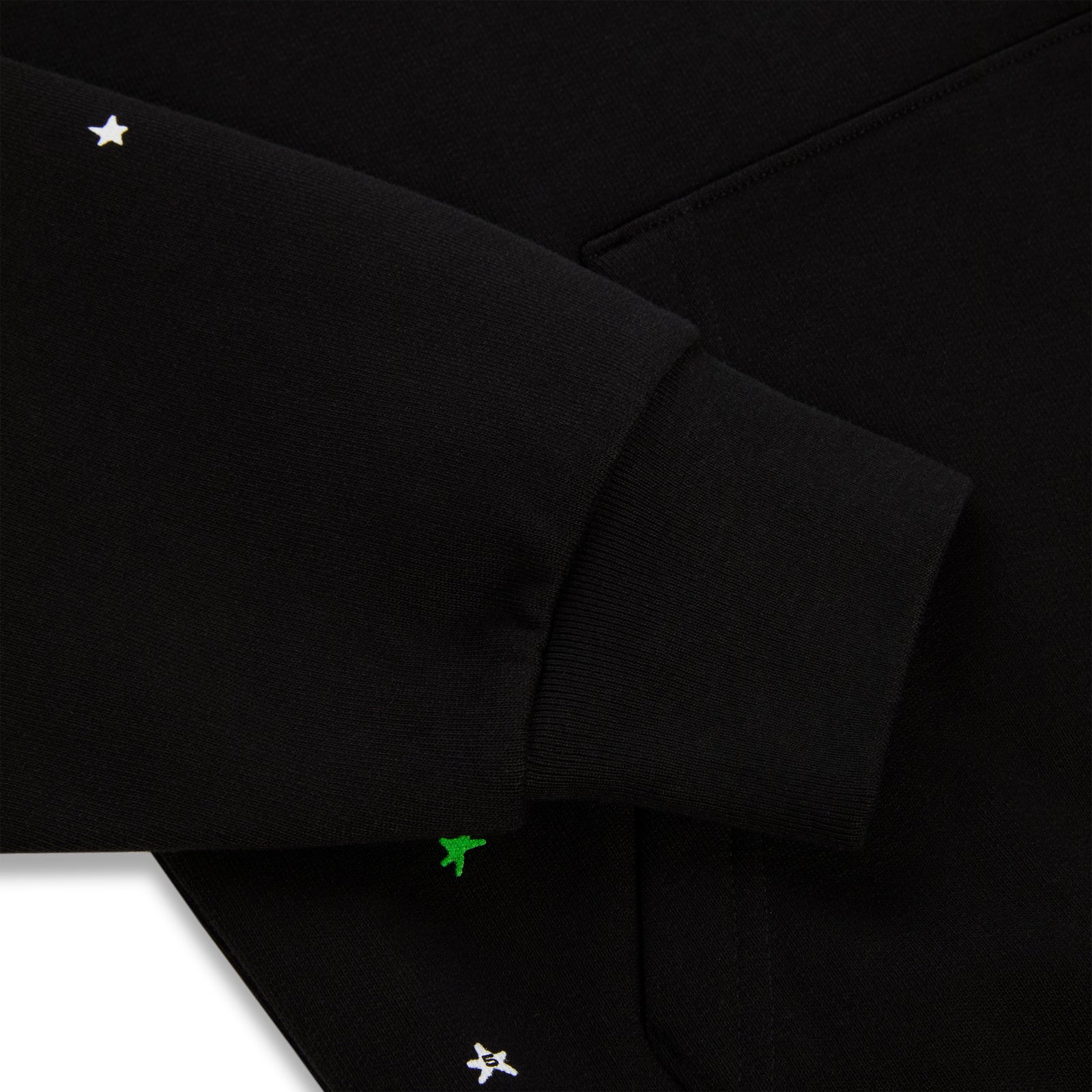 Black heavy web hoodie with white stars and green puff print details.