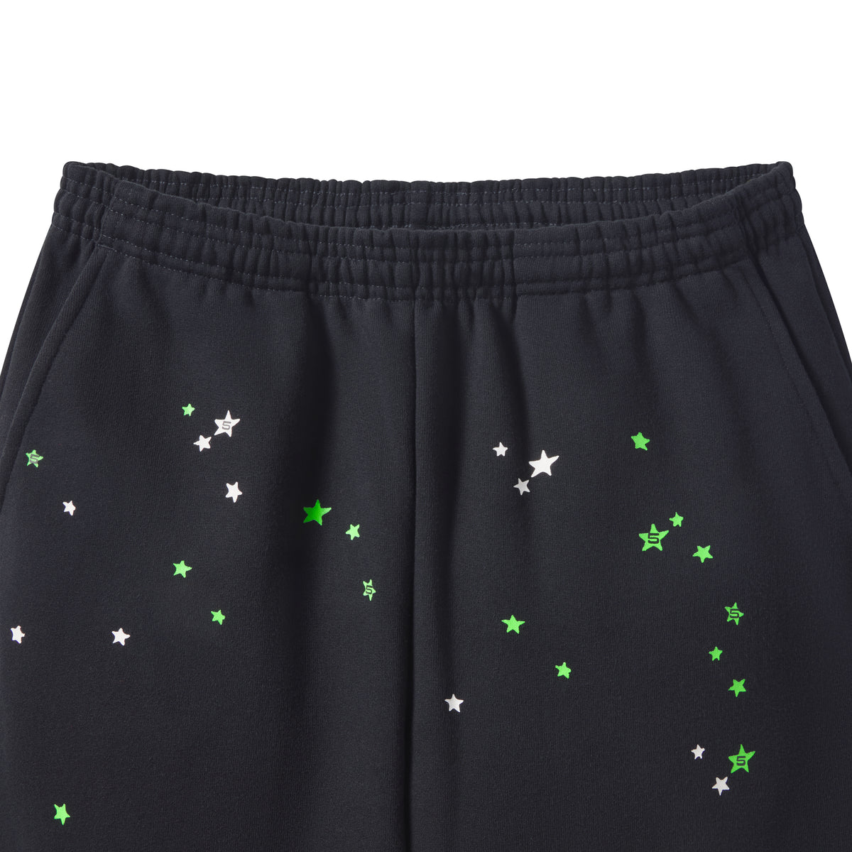 Black cotton fleece sweatpants featuring a scattered green and white star graphic print and an elasticized waistband.
