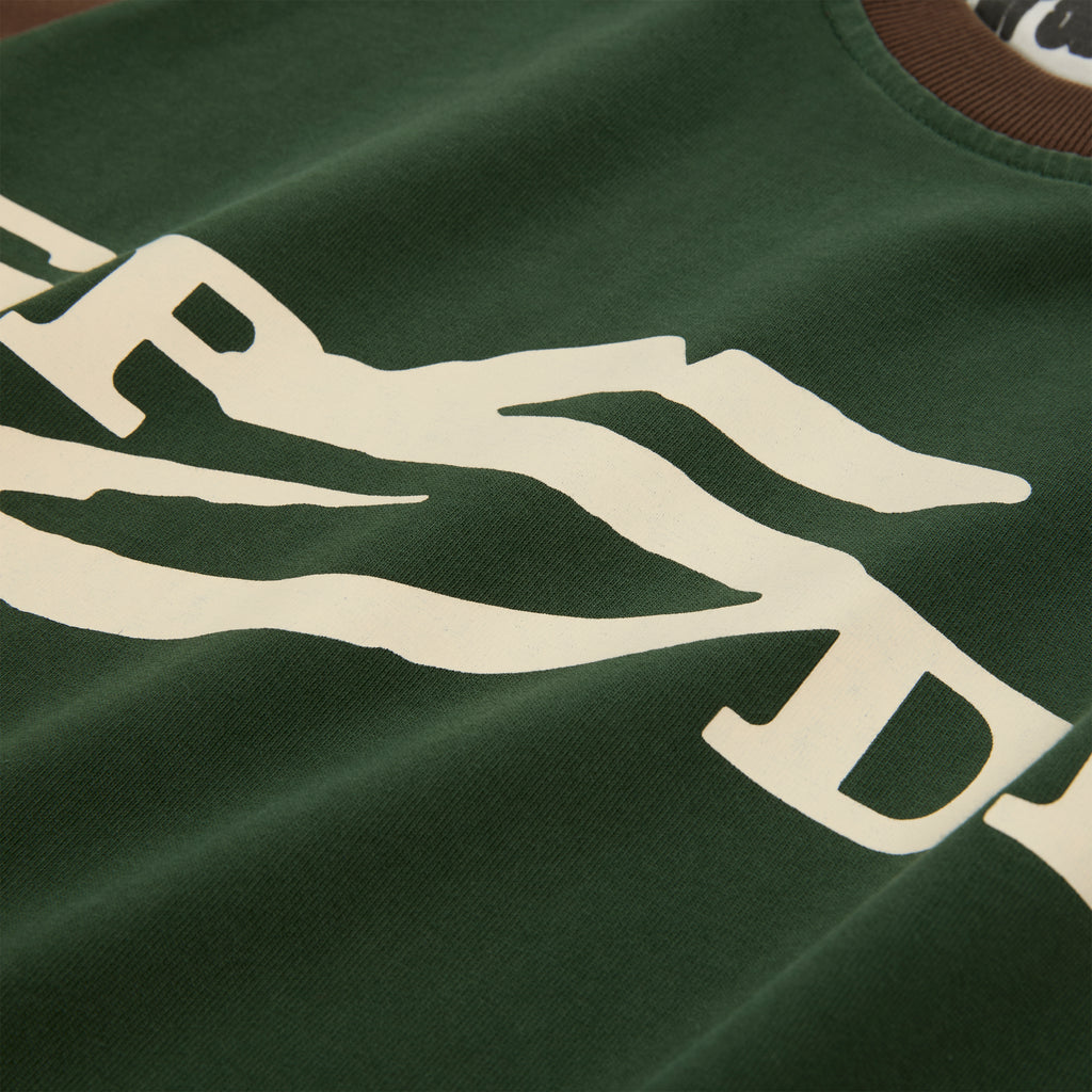 Green 5UKI TEE with cream graphic print, brown collar, and color-block design.