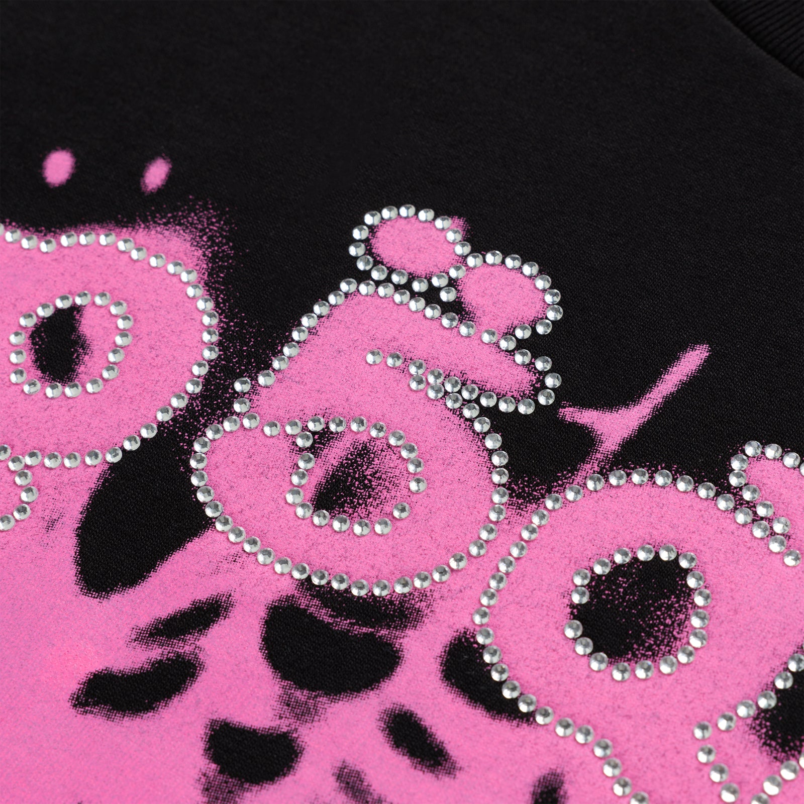 Black cotton tee with "SP5DER" text in pink spray paint effect, outlined with rhinestones.