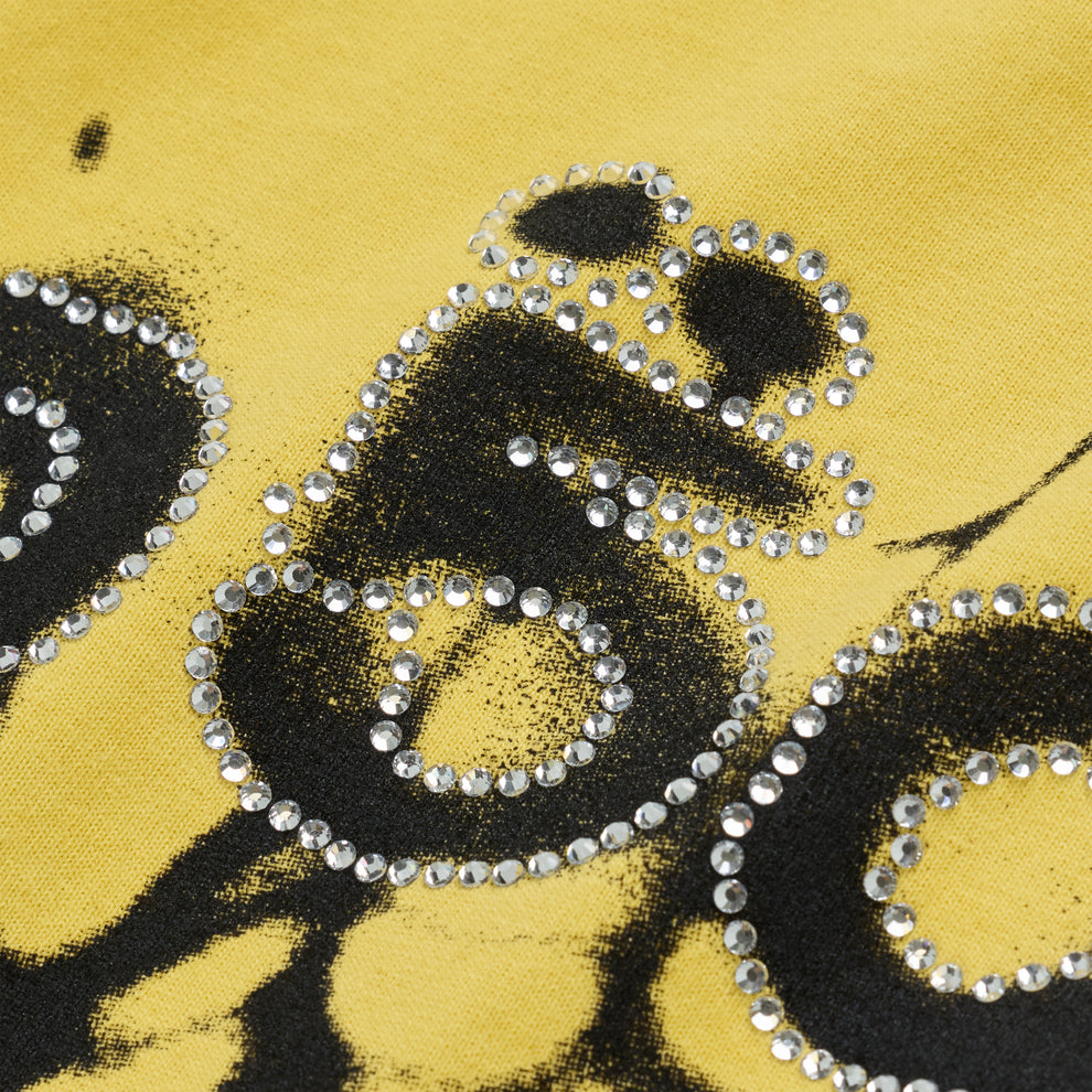 Close-up of OG WEB V2 TEE in yellow with black graphic and rhinestone embellishments.