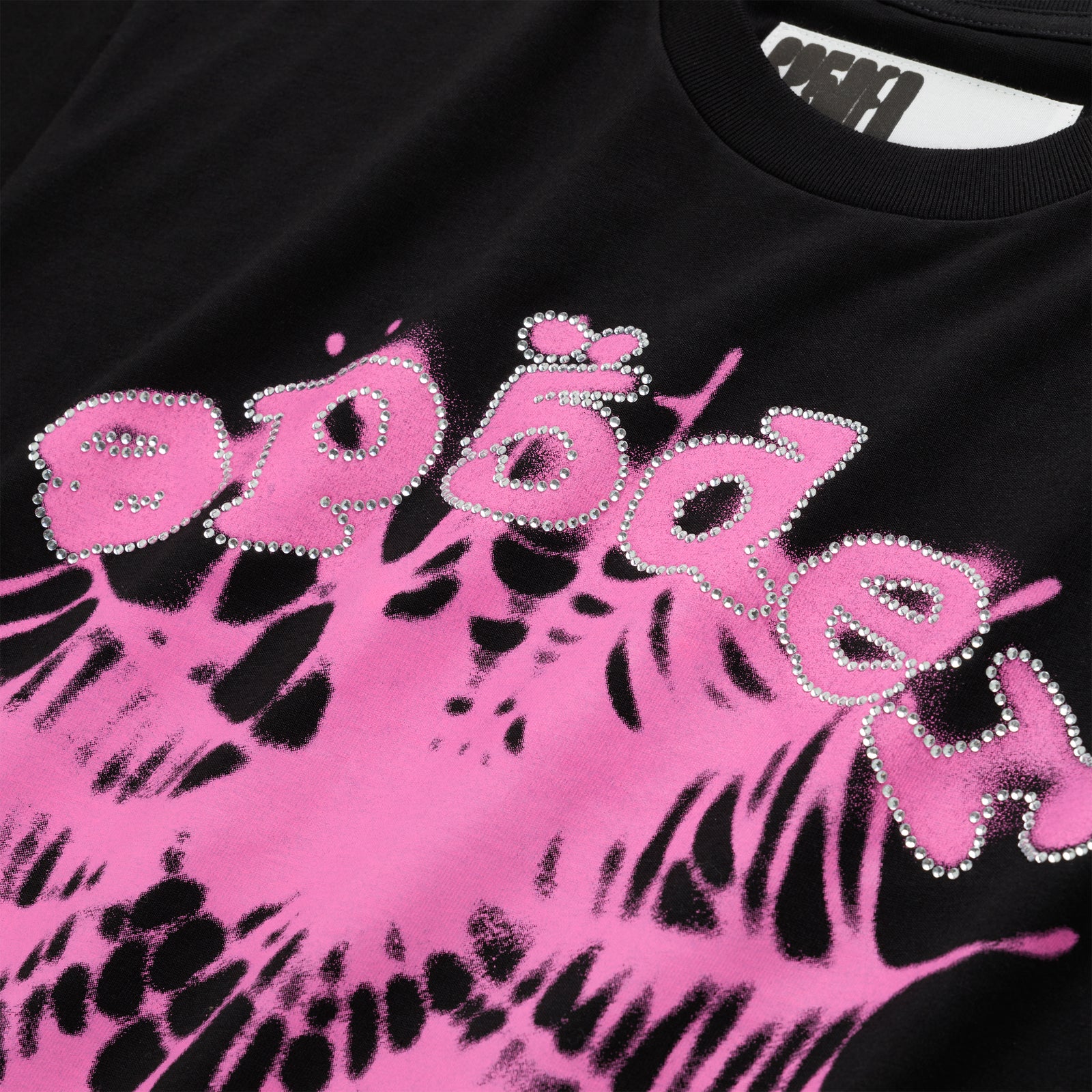 Black cotton tee with "SP5DER" text in rhinestones over a pink web graphic.