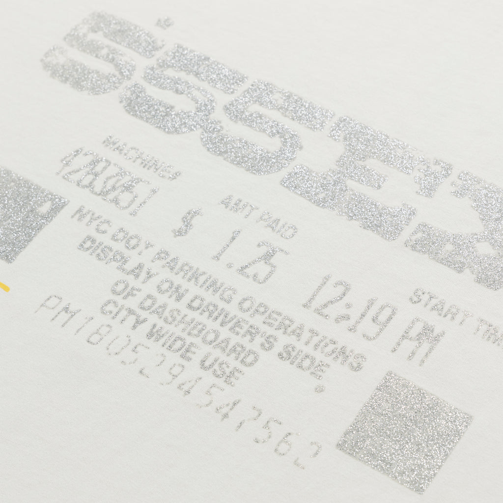 White cotton tee with glittery silver graphic print resembling a parking ticket.