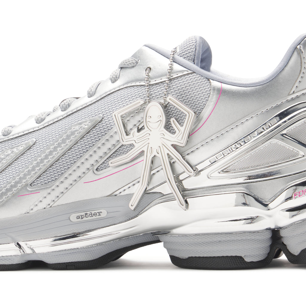 SP5DER x adidas F50 Adizero sneaker with metallic silver upper, mesh, chrome overlays, pink accents, and a spider charm.