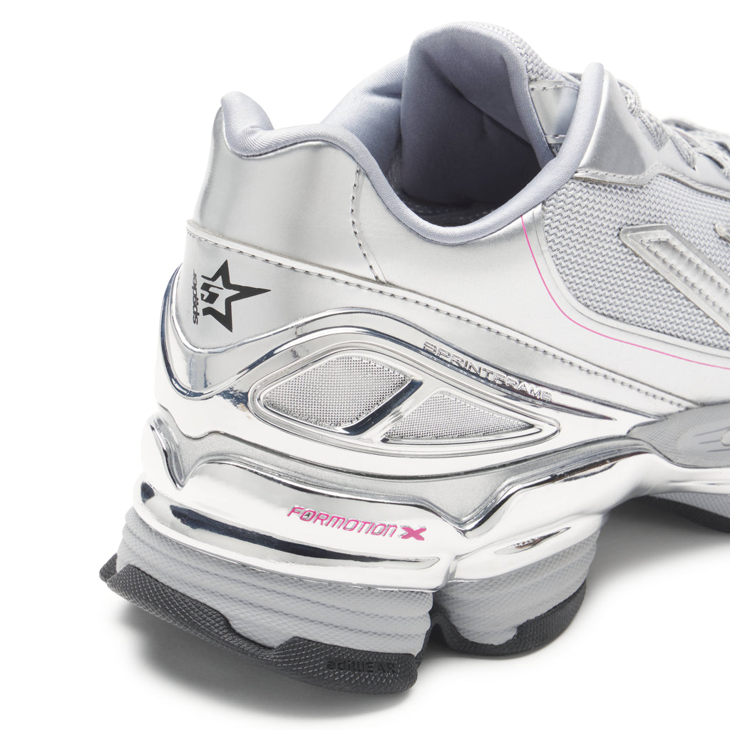 SP5DER x ADIDAS F50 ADIZERO sneaker with metallic silver synthetic and mesh, chrome overlays, pink accents, and co-branding.