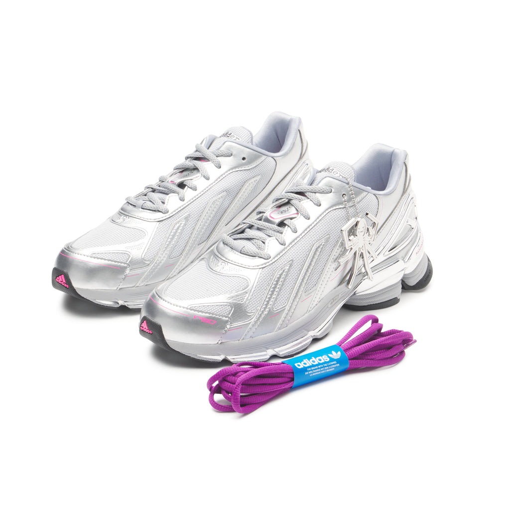 SP5DER x adidas F50 Adizero sneakers in metallic silver with pink accents, mesh, chrome overlays, and a removable charm.