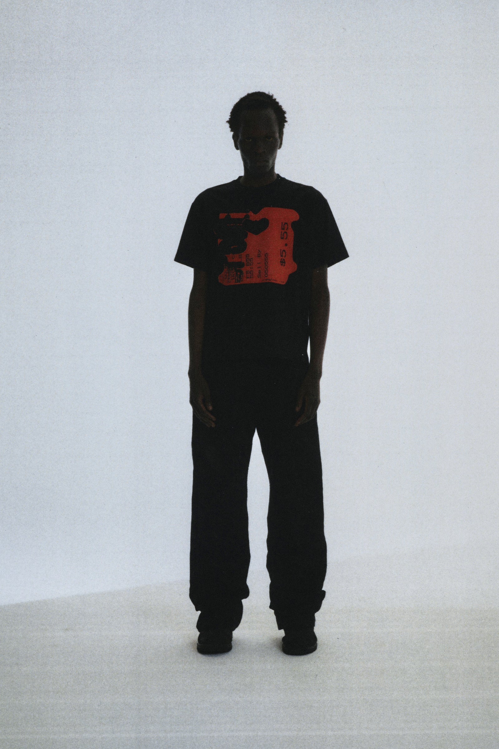 Black cotton Toast Tee with red graphic print, worn by a person against a white background.
