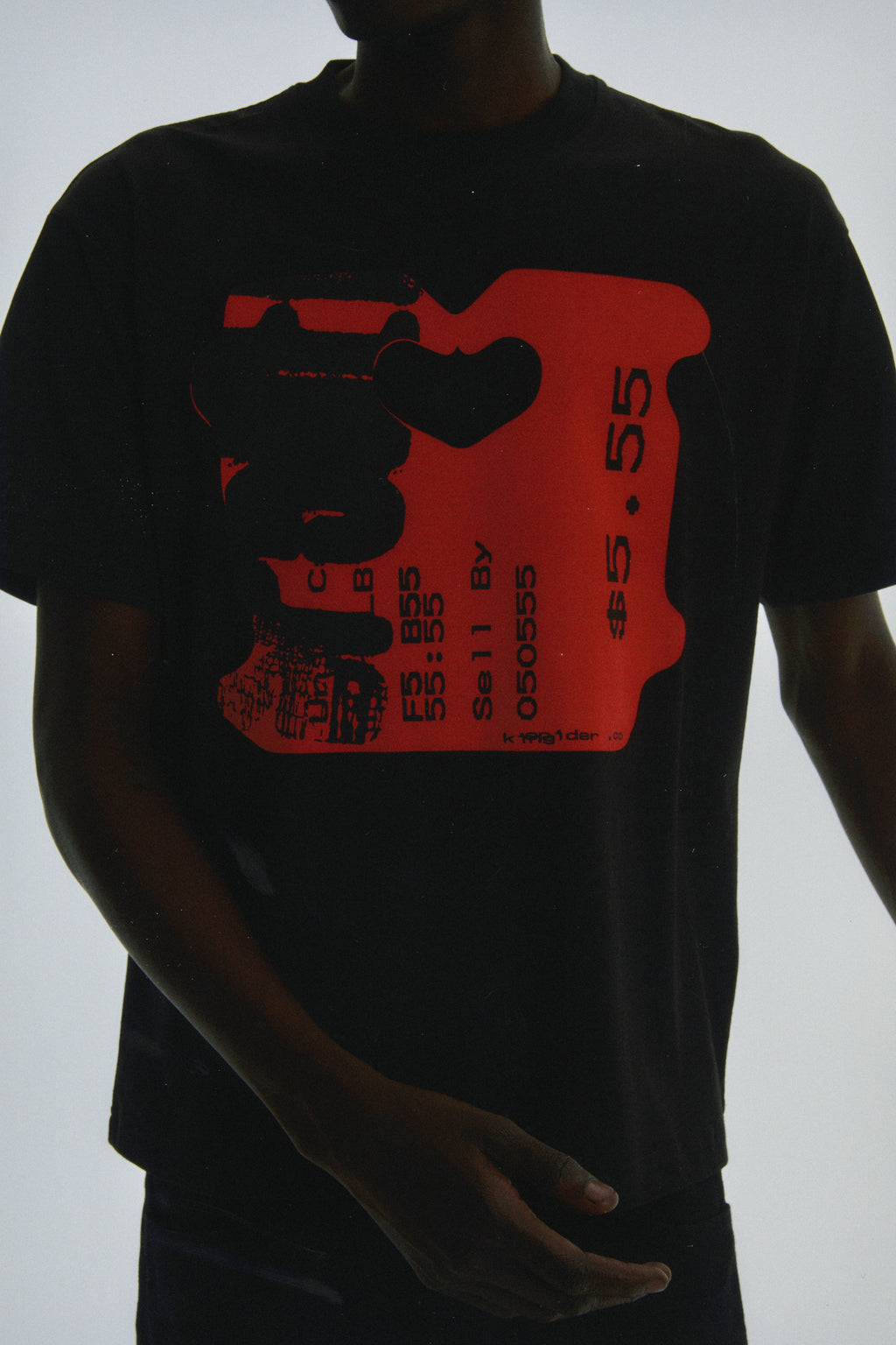 Black cotton TOAST TEE with a bold red graphic print resembling a bread tag, featuring "5.55" and text.