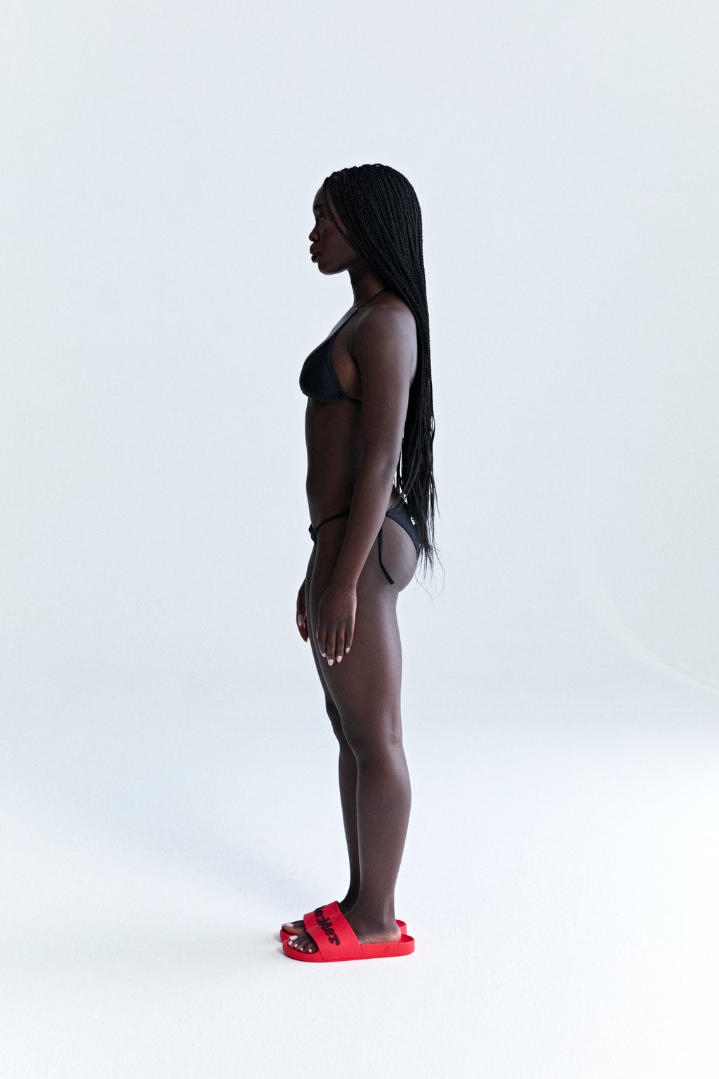 Black stretch nylon jersey ARAIGNÉE BIKINI set with rope ties, crest graphic, and logo.
