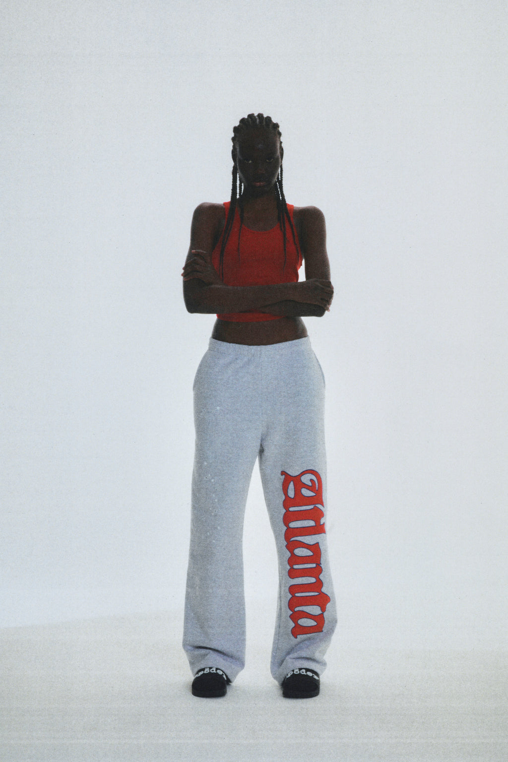 Light grey wide-leg sweatpants with "Atlanta" in red script down the left leg and scattered stars.