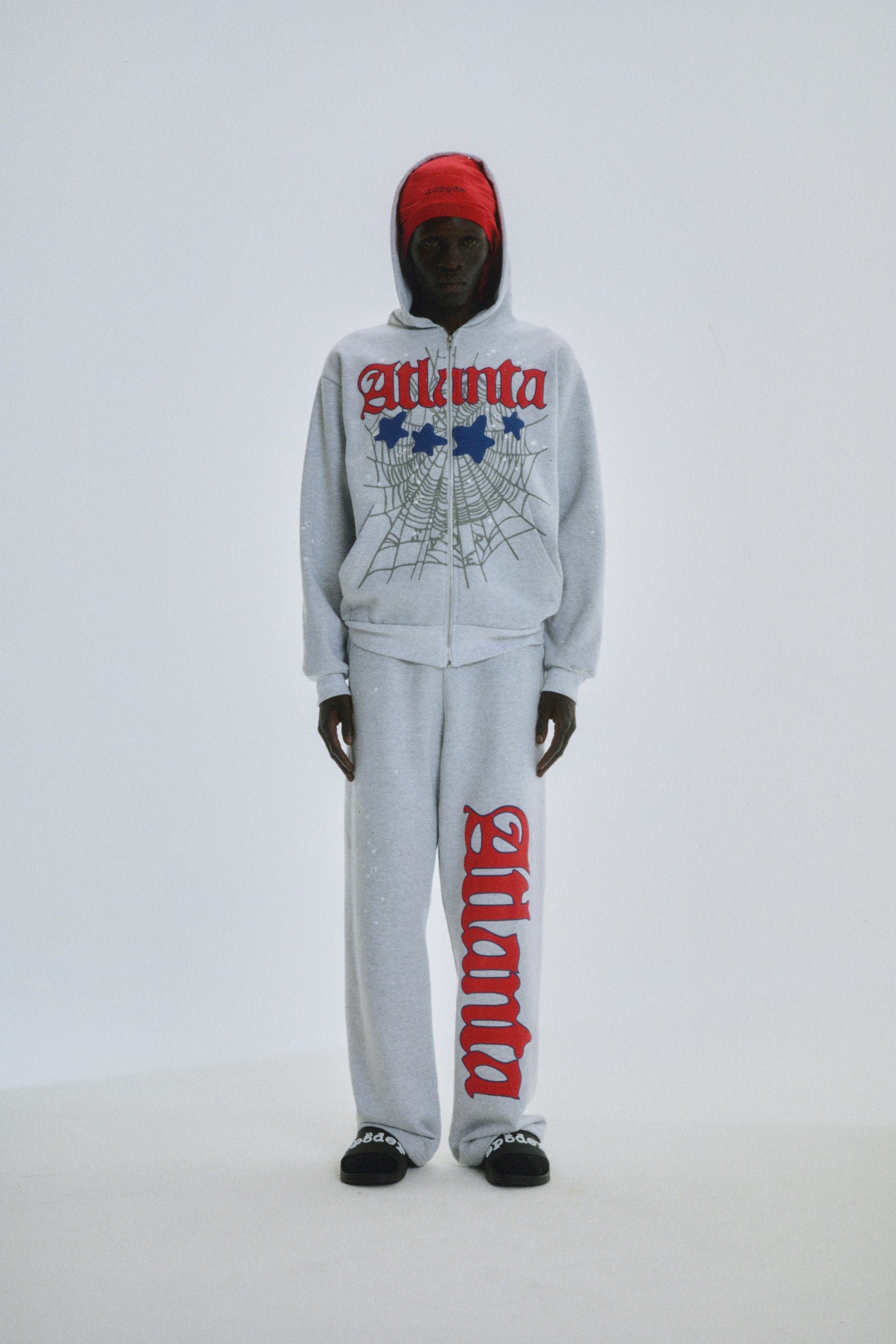 Grey cotton fleece Atlanta Full Zip Hoodie and sweatpants with red script, web, and star prints.