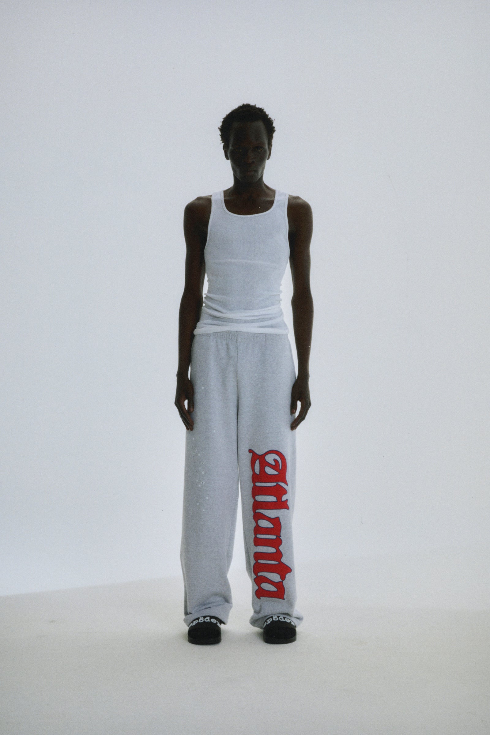 Grey wide-leg sweatpants with red "Atlanta" script and scattered stars on 100% cotton fleece.