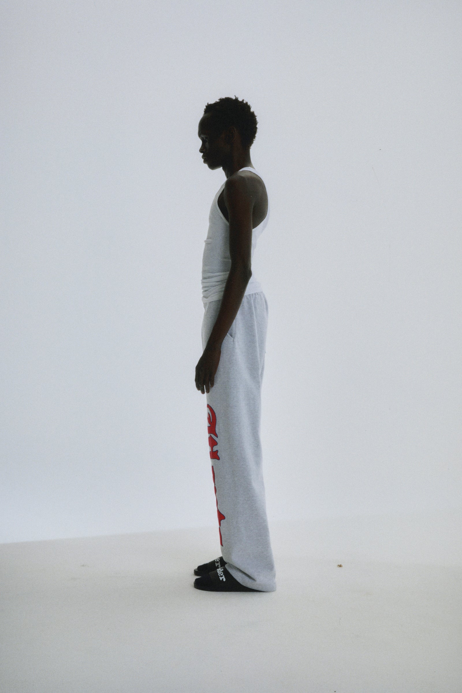 Model in light grey wide-leg cotton fleece sweatpants with red "Atlanta" script and star print.
