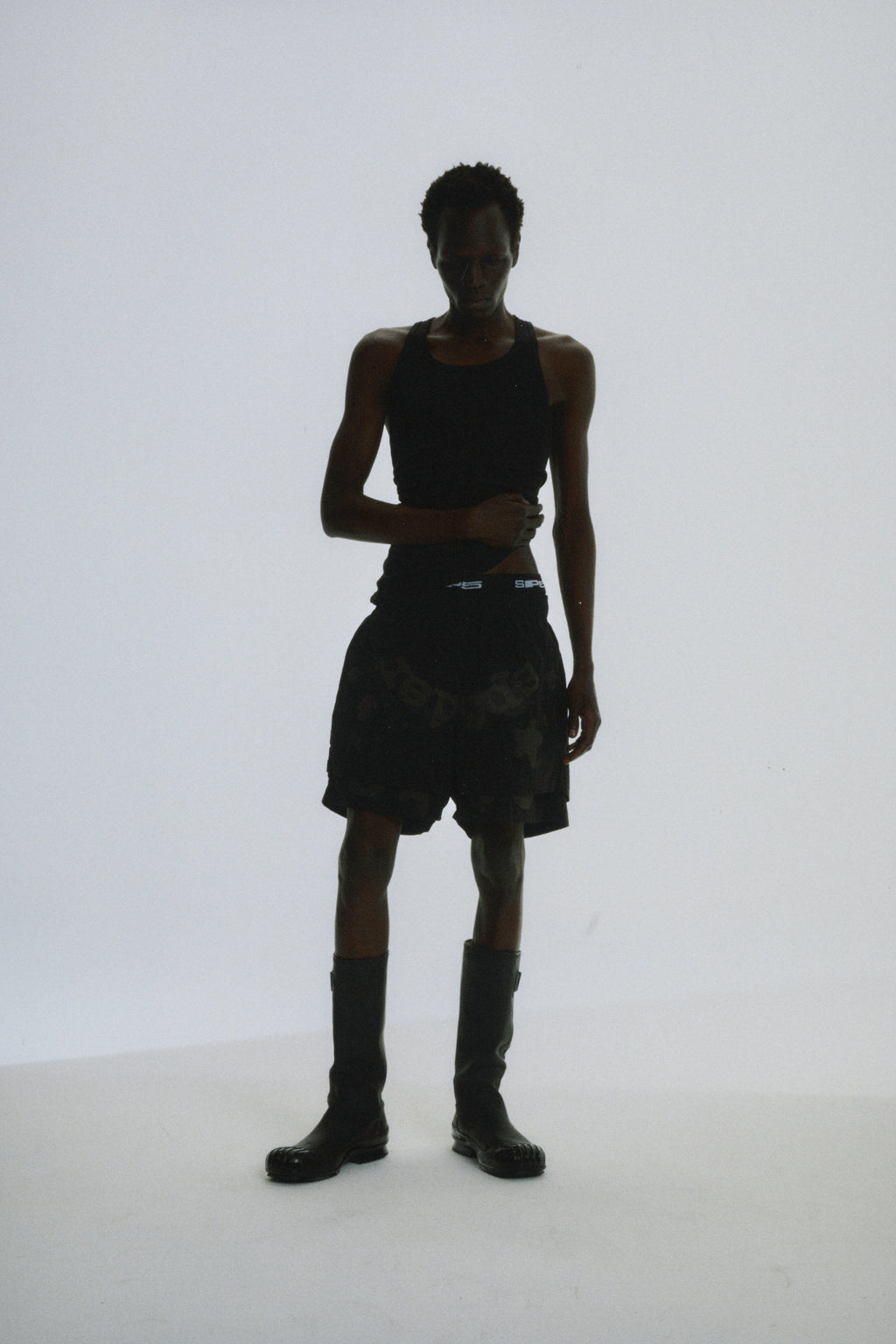 Black Beluga Double Layer Short on a model, featuring water-repellent nylon, high-low design, and puff print.