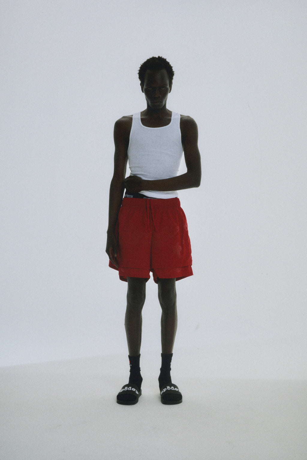 Man in red Beluga Double Layer Shorts, 4oz water repellent nylon, with high-low design and puff print.