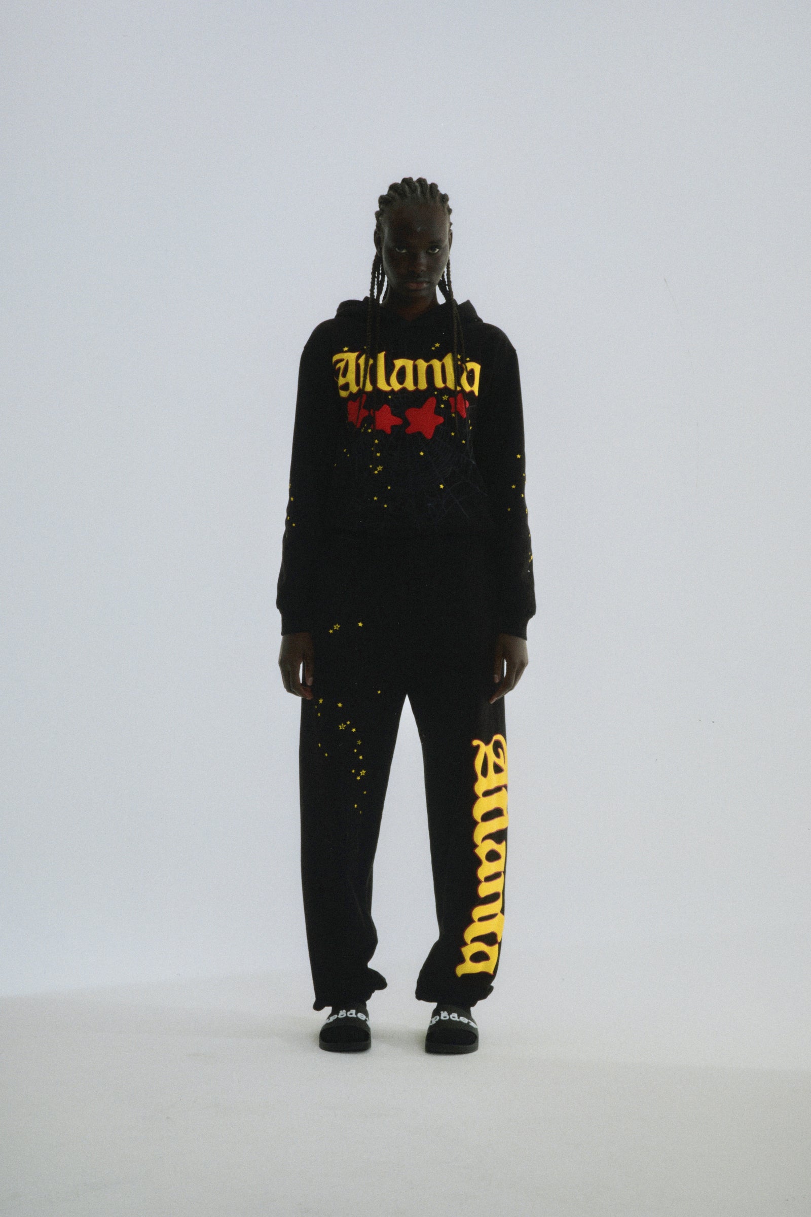 Black 100% cotton fleece Atlanta hoodie and sweatpants with yellow puff print script and scattered stars.
