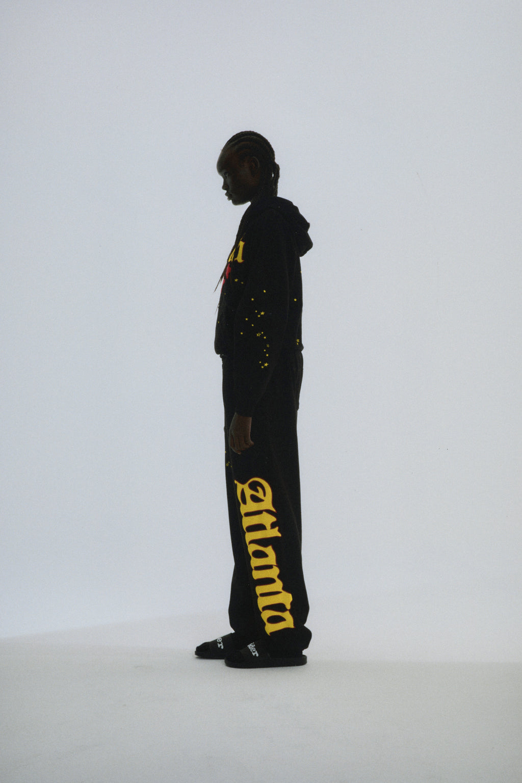 Black Atlanta hoodie and sweatpants with yellow puff print script, web, and scattered star designs.