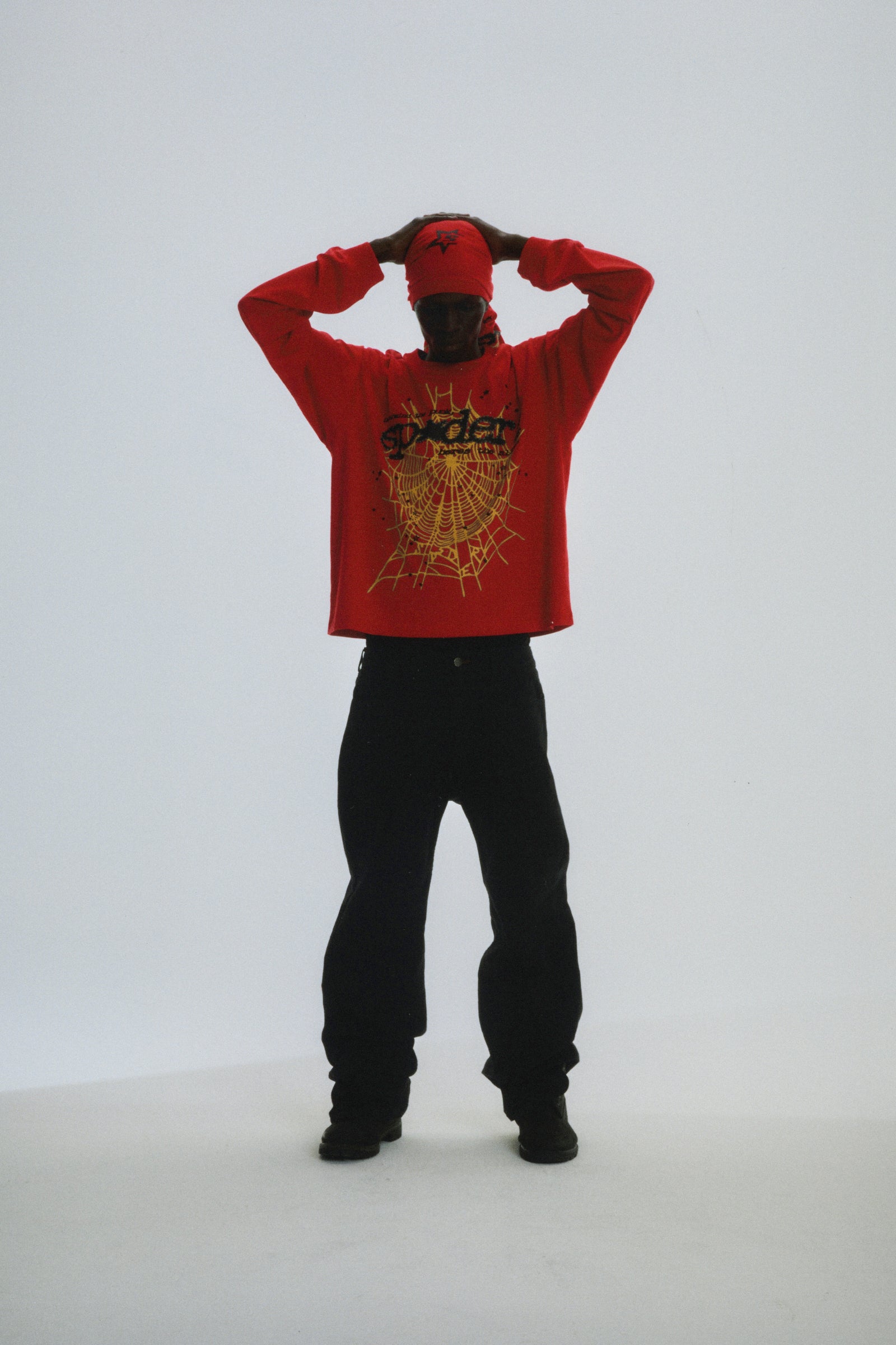 Red PUNK V2 LONGSLEEVE with yellow spider web graphic, worn by a model with black pants.