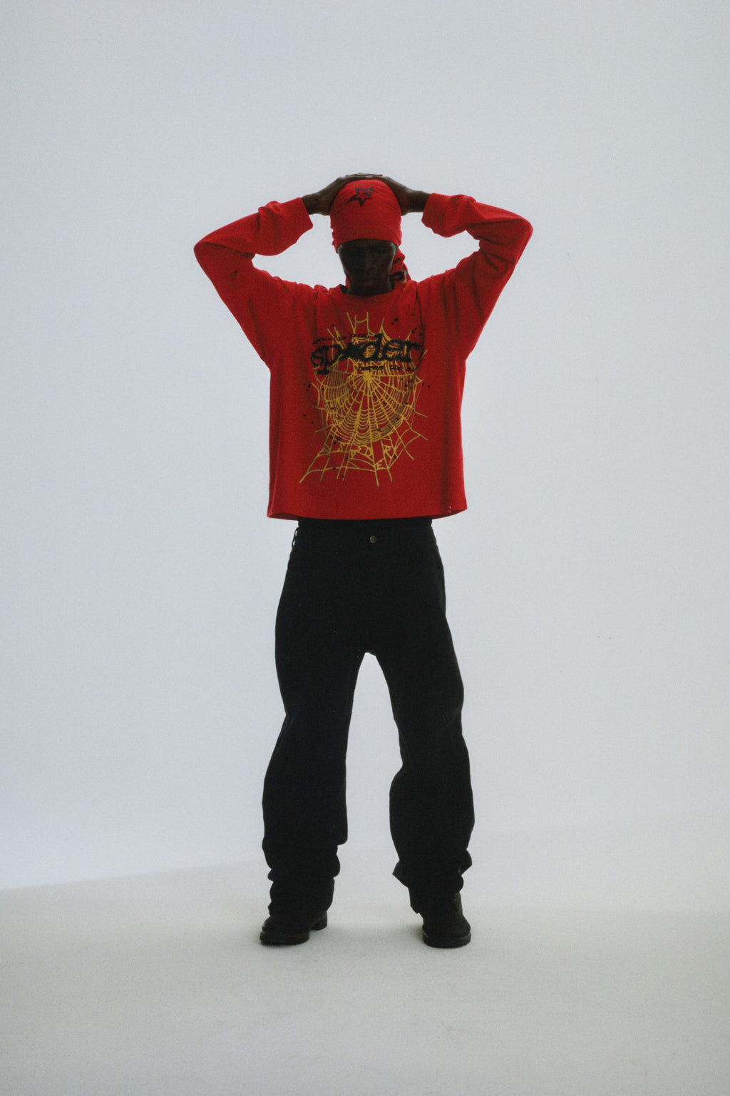 Red PUNK V2 LONGSLEEVE with yellow spider web graphic, worn by a model with black pants.