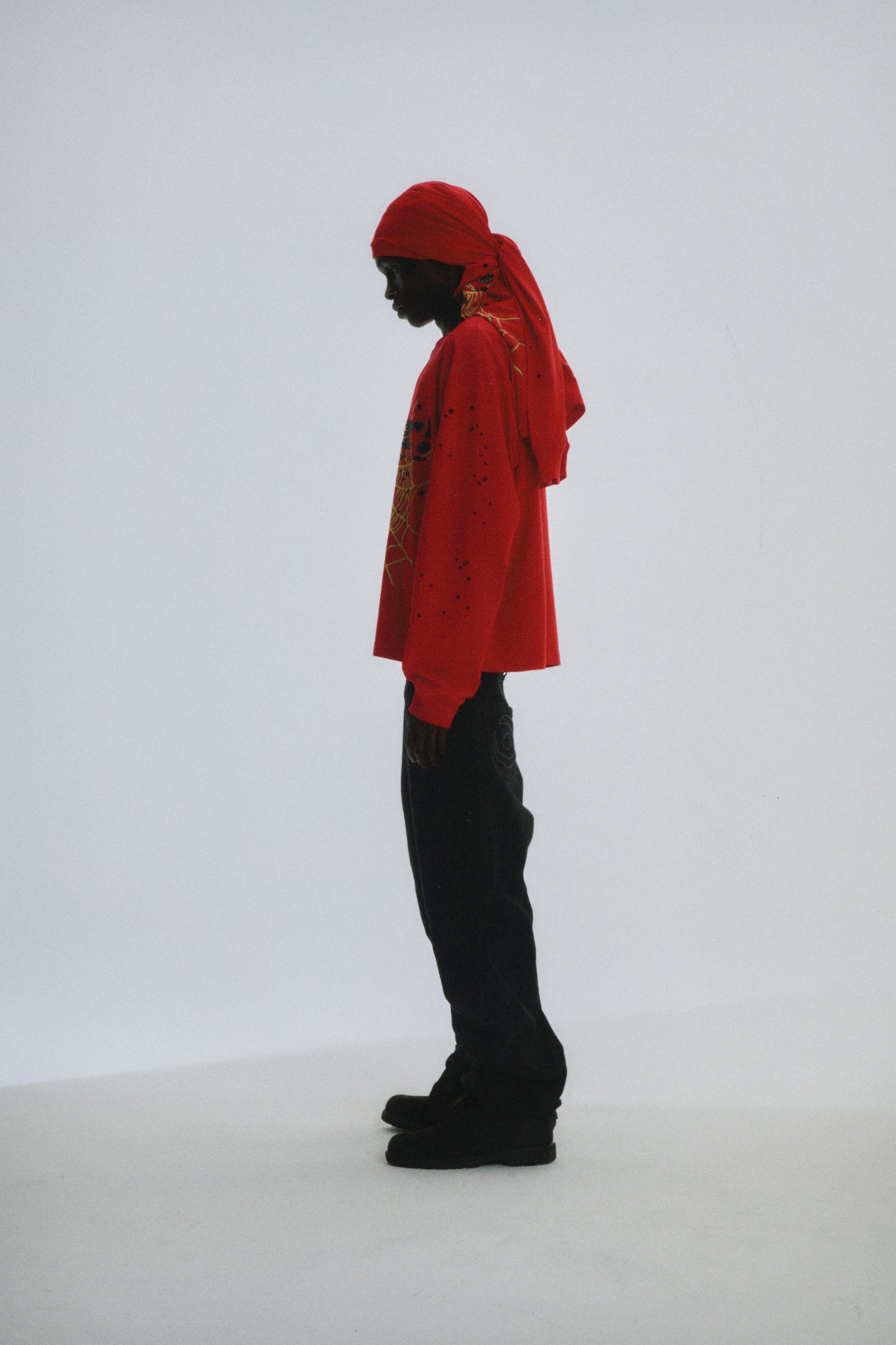 Red PUNK V2 LONGSLEEVE with P*NK SP5DER motif, web, and scattered stars on a model.