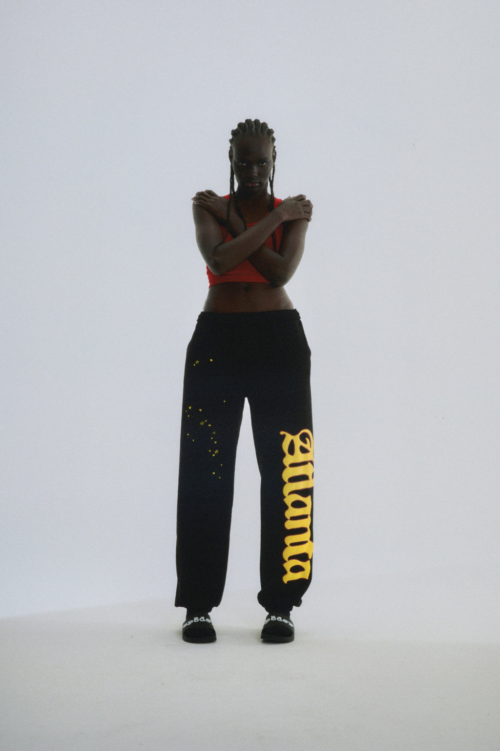 Black Atlanta Sweatpants with yellow script text and scattered stars, worn by a model.