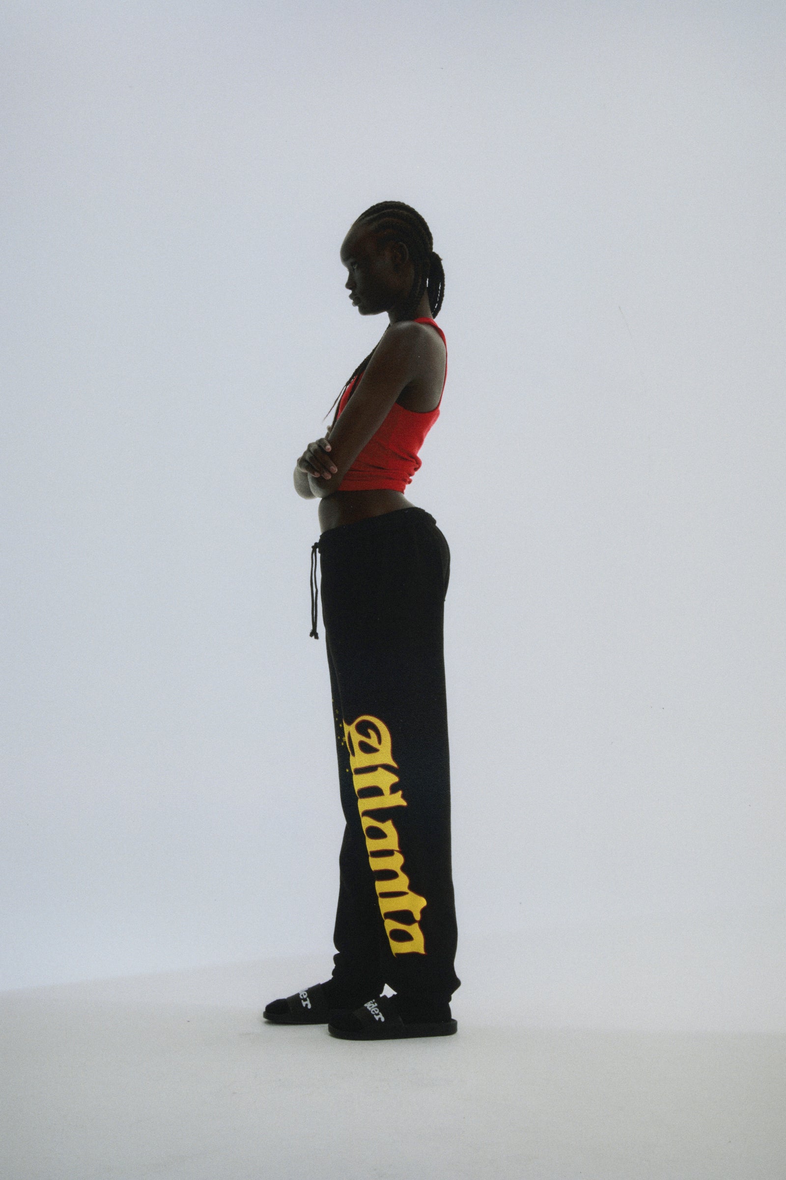 Black cotton fleece sweatpants with yellow "Atlanta" script and star print, elastic drawstring waist.