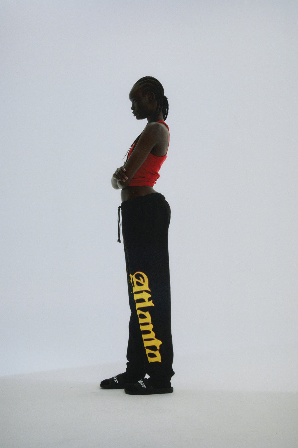 Black cotton fleece sweatpants with yellow "Atlanta" script and star print, elastic drawstring waist.