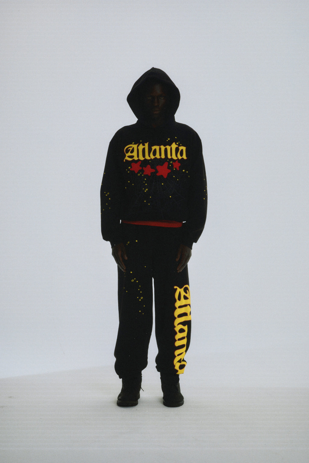 Black 13oz cotton fleece Atlanta hoodie and sweatpants with yellow puff print script and red stars.