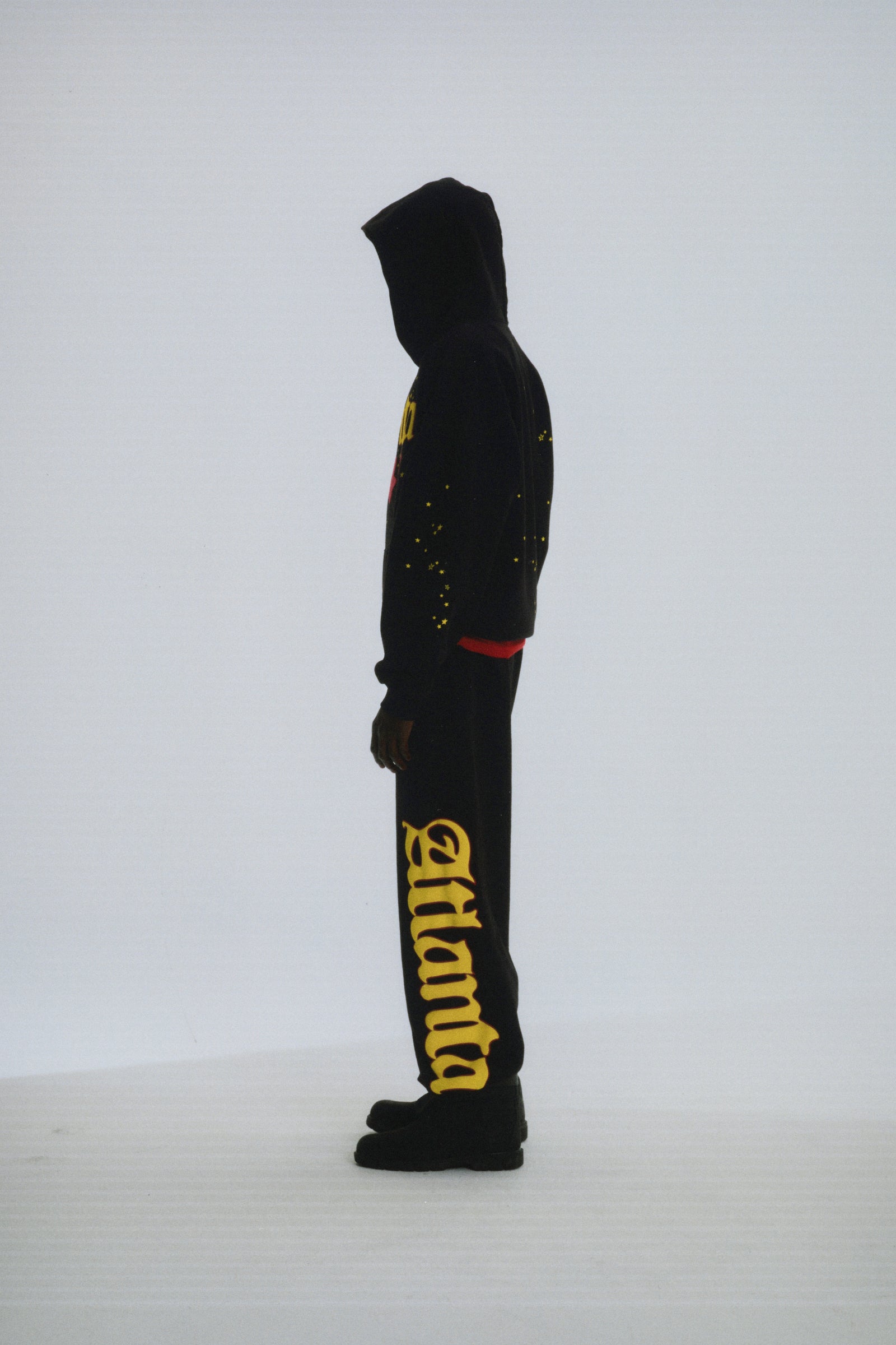 Black 100% cotton fleece Atlanta hoodie and sweatpants with yellow script text and scattered star print.