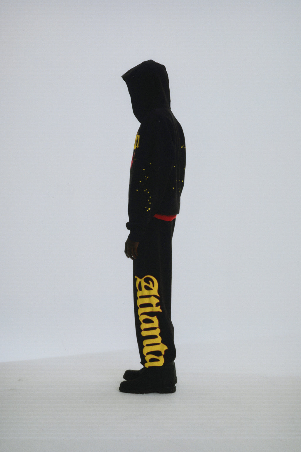 Black 100% cotton fleece Atlanta hoodie and sweatpants with yellow script text and scattered star print.