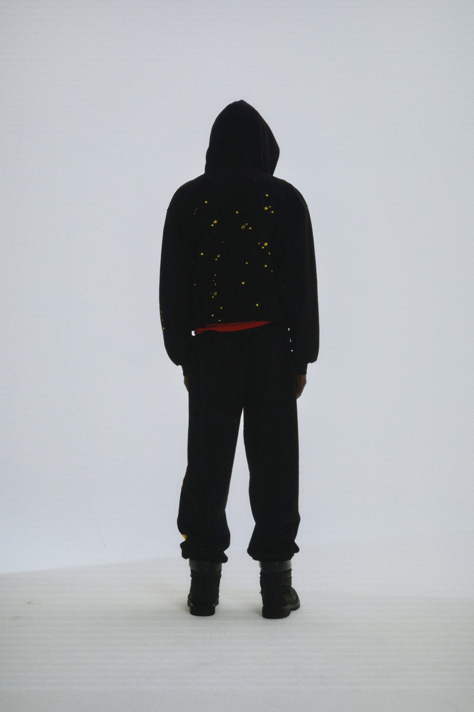 Black 13oz cotton fleece Atlanta hoodie with yellow scattered star print, worn by a person from behind.