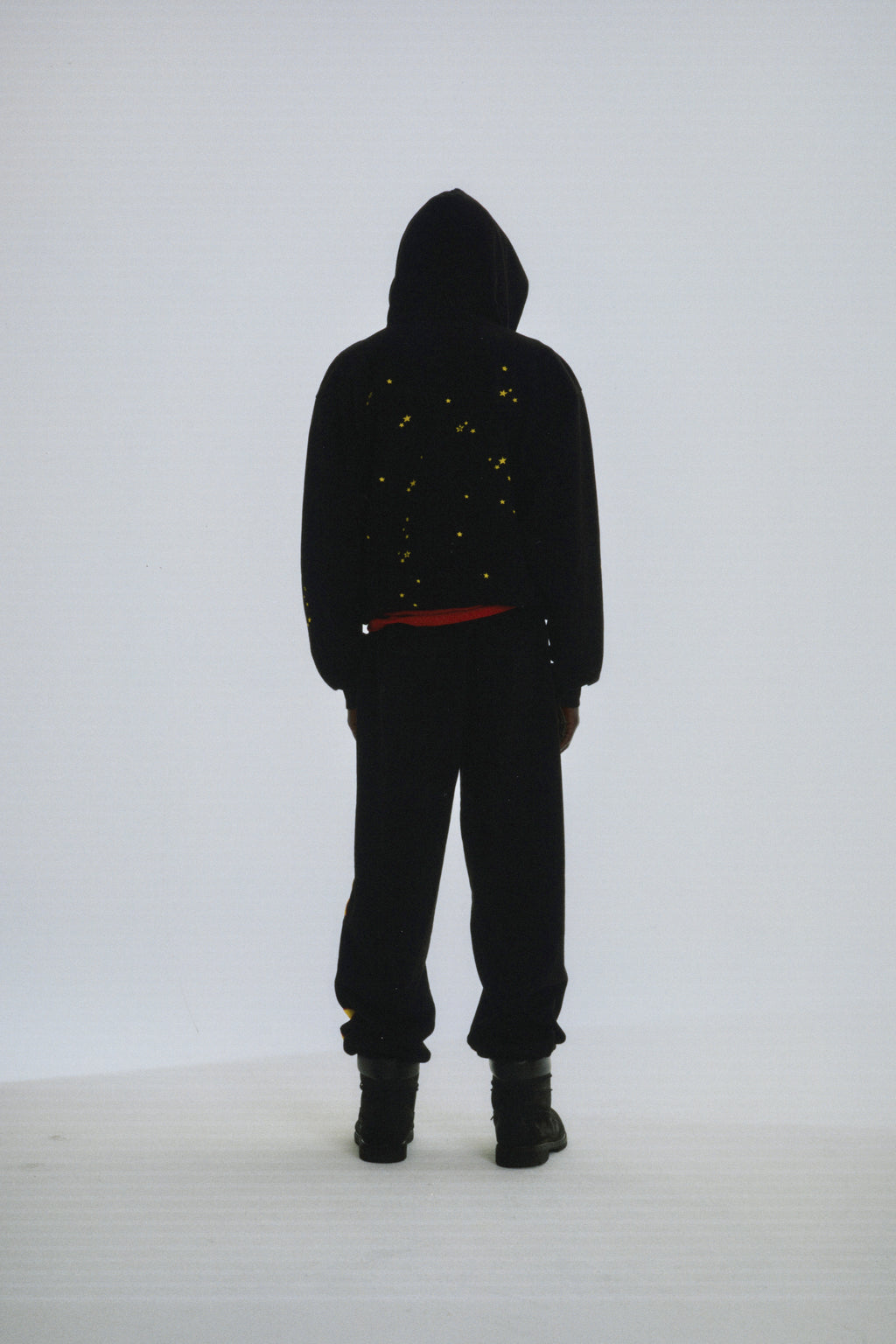 Black 13oz cotton fleece Atlanta hoodie with yellow scattered star print, worn by a person from behind.