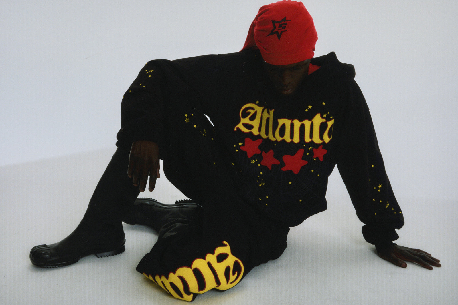 Black cotton fleece Atlanta hoodie with yellow script, red stars, and scattered star print.