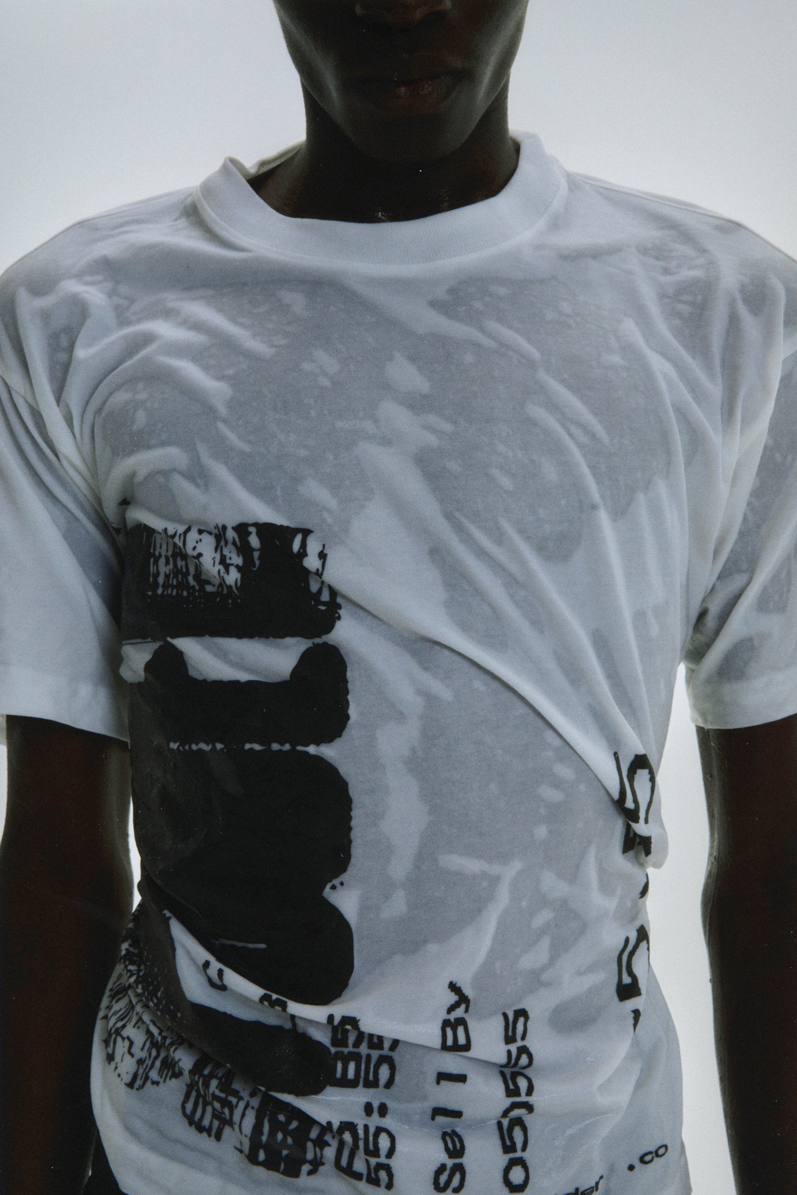White 100% cotton Commerce Tee with black graphic print, wet and draped on a model.