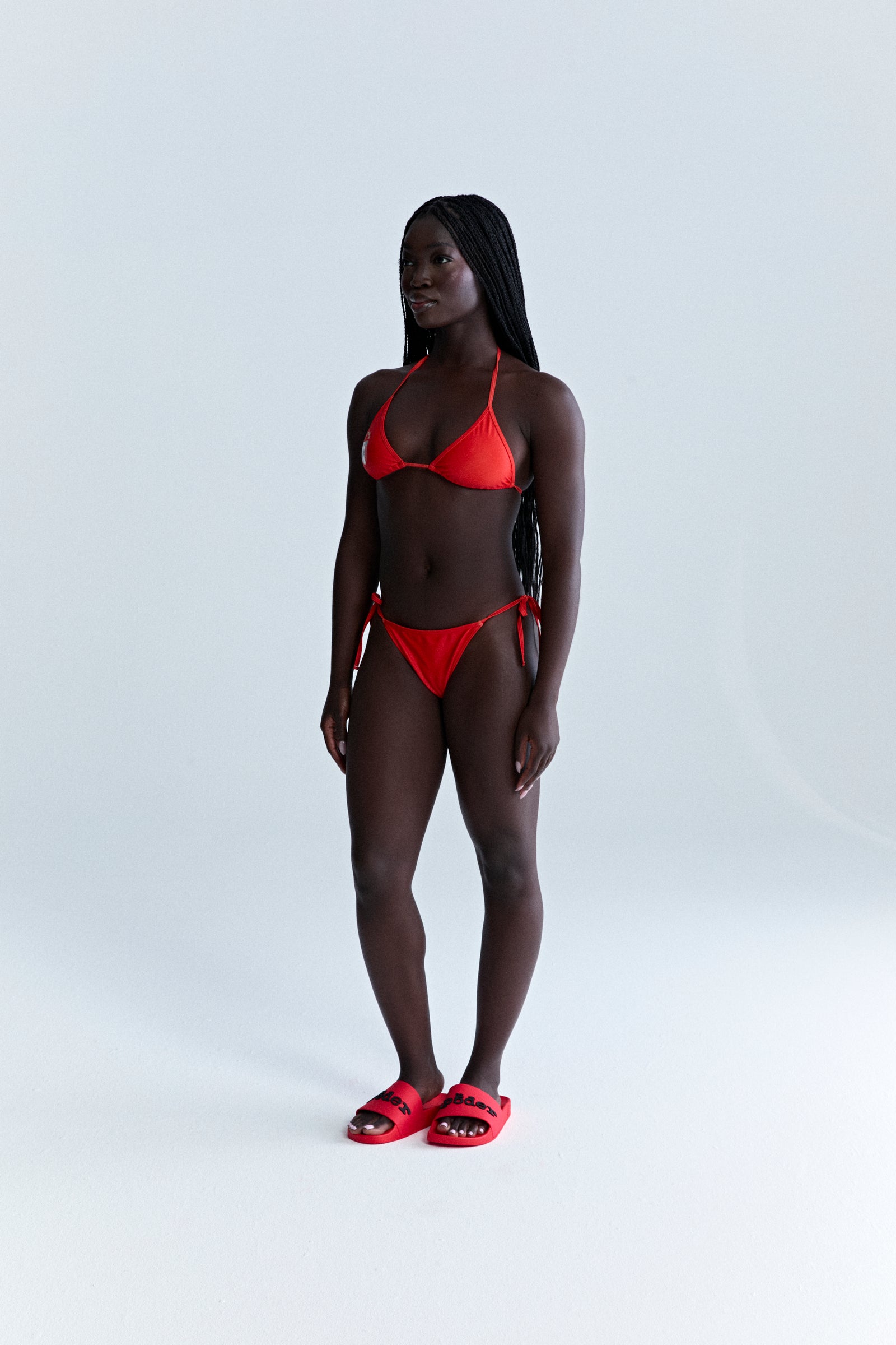 Red ARAIGNÉE BIKINI set with triangle top, rope ties, and stretch nylon jersey.