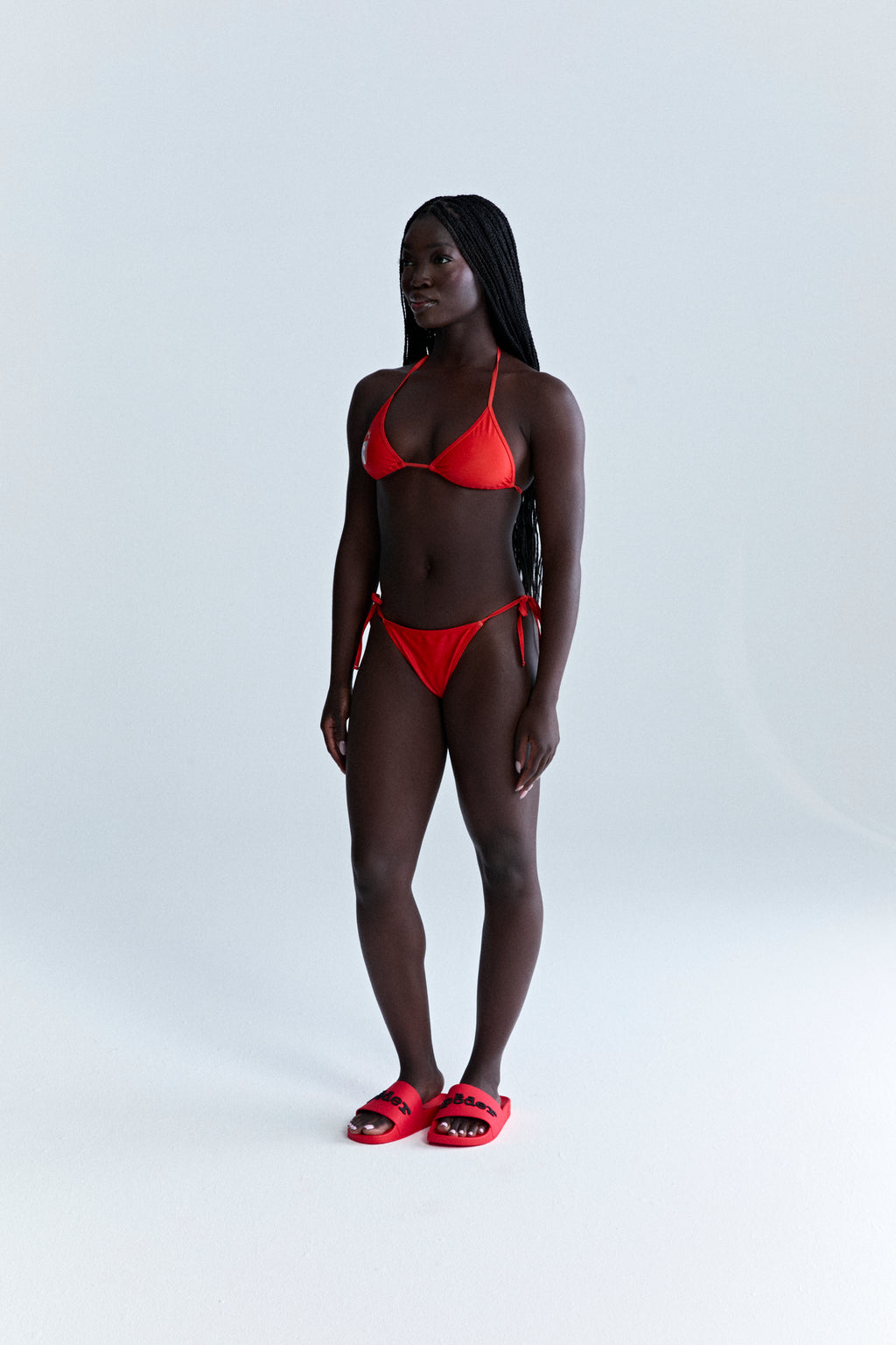 Red ARAIGNÉE BIKINI set with triangle top, rope ties, and stretch nylon jersey.
