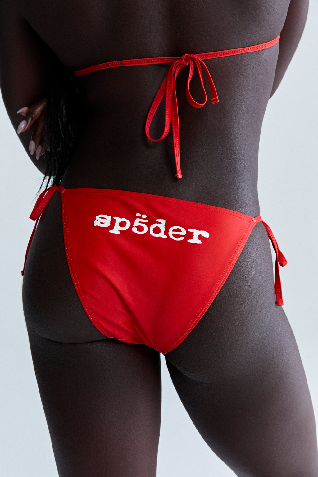 Red stretch nylon jersey bikini bottom with white "spöeder" logo on backside and rope ties.