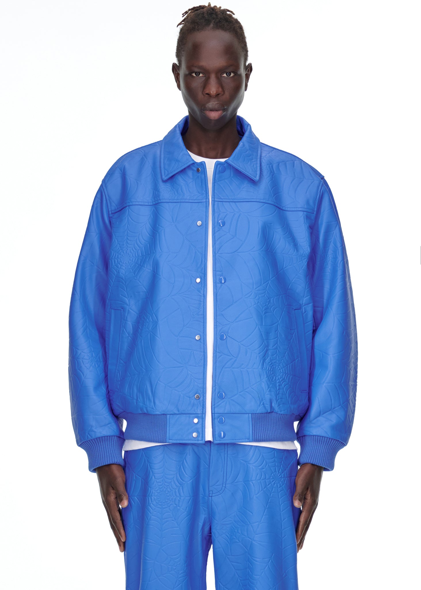 Male model in a blue debossed web cowskin leather jacket with a spread collar and press-stud closure.