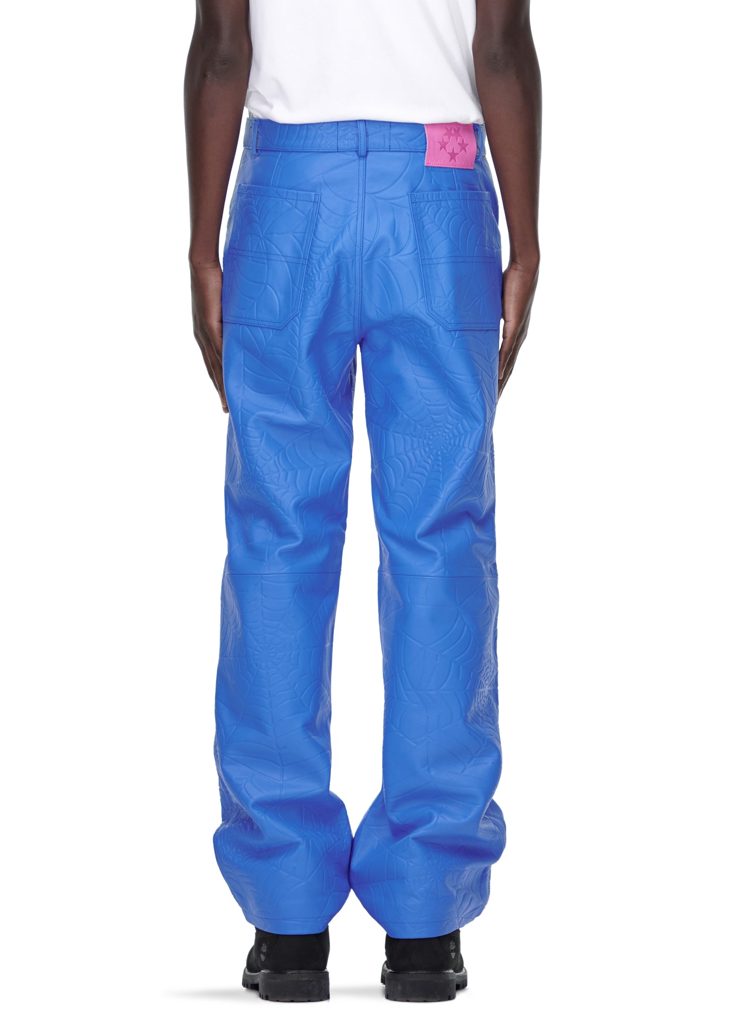 Blue debossed web leather pants with a pink suede logo patch, worn by a male model.