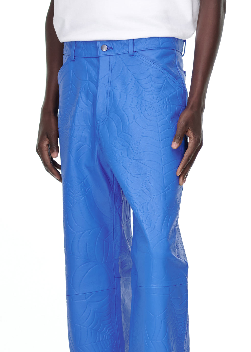 Male model wearing blue debossed web cowskin leather pants with four-pocket styling and button fly.