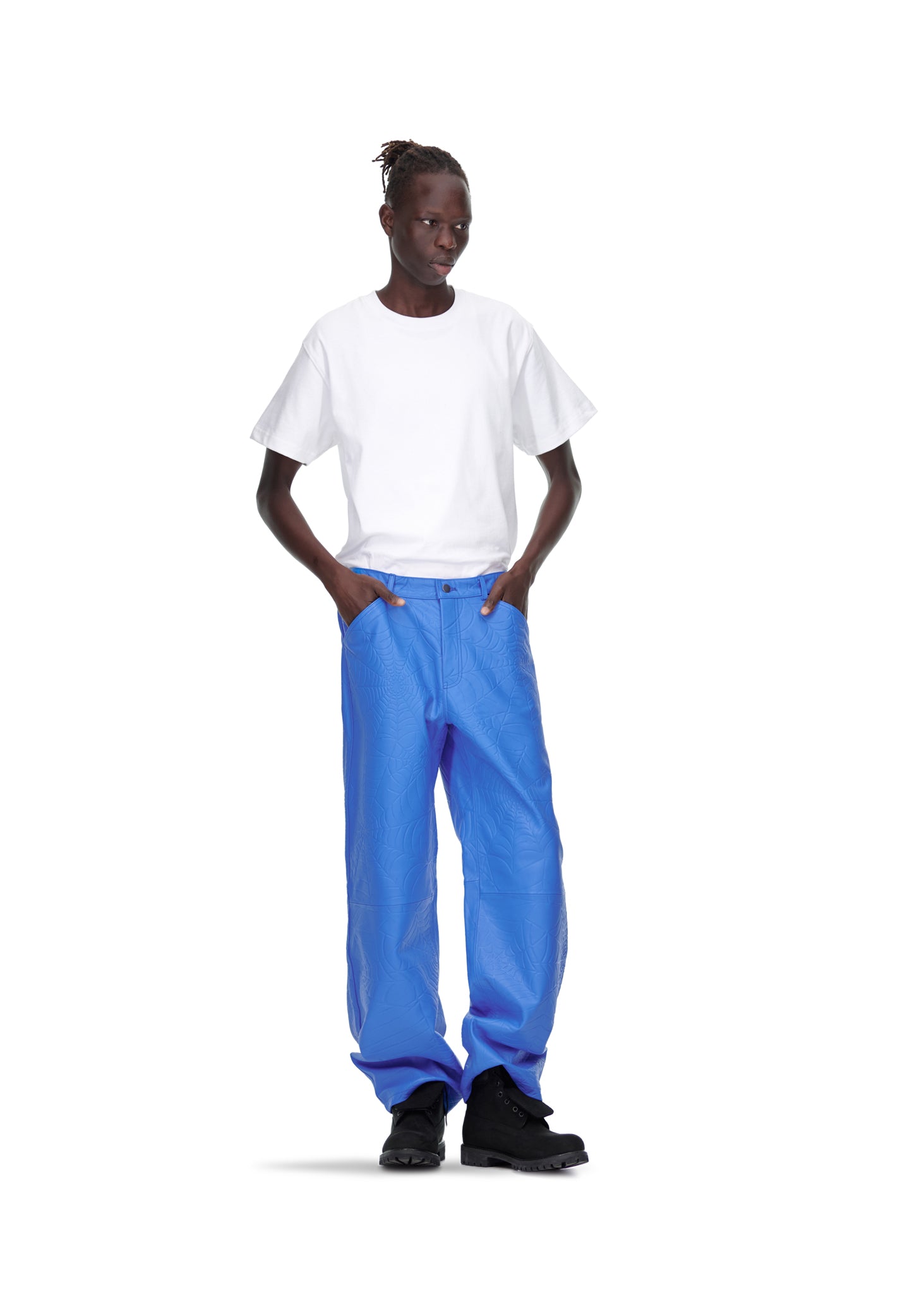 Male model in blue debossed web cowskin leather pants, white tee, and black boots.